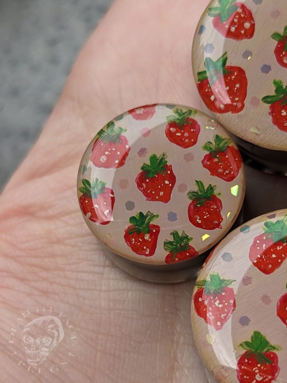 Silver ear plugs with hand-painted strawberries and rainbow glitter