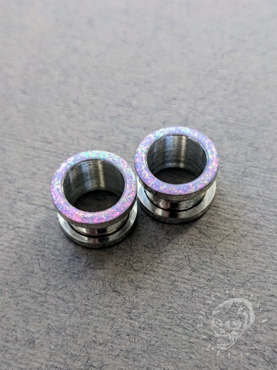 Magically opalescent ear plugs in surgical steel with lilac sparkles in pink, mint, gold, and green opalescent glitter