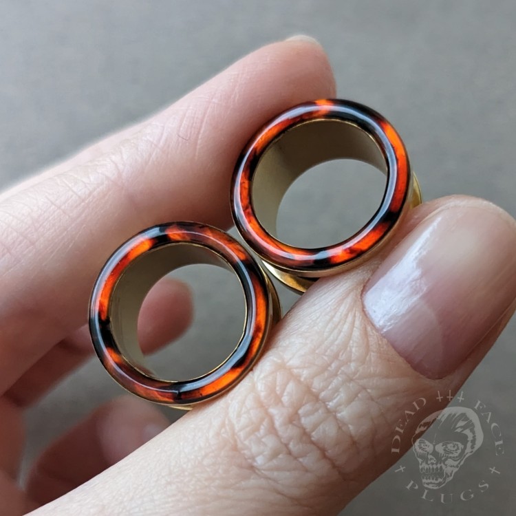 Gold screw-on ear plugs with orange and dark brown tortoiseshell resin