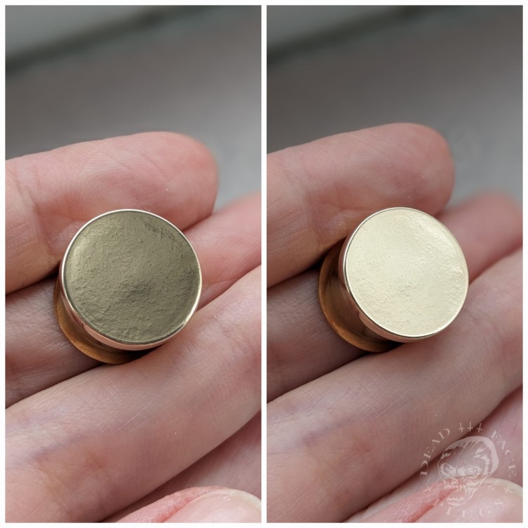 Mirror finished bronze disc plugs looking like solid gold gauges on stainless steel tunnels