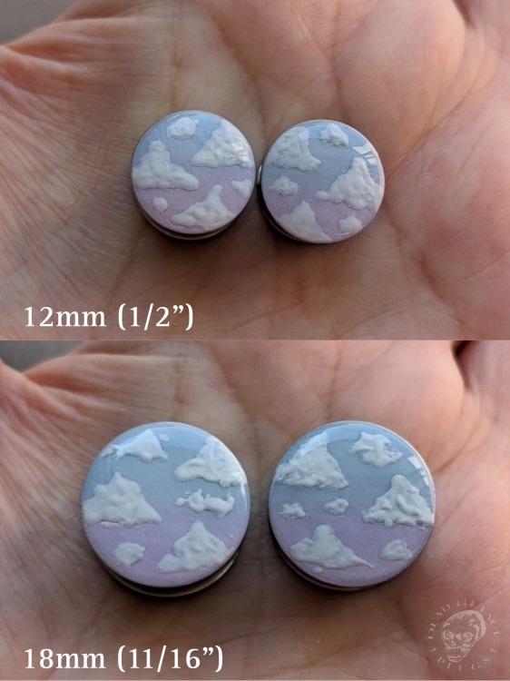 Silver ear plugs with blue and lilac violet purple ombre effect, decorated with fluffy white clouds.