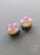 Silver ear plugs with pink and yellow ombre effect, decorated with fluffy white clouds.