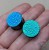 Black steel ear plugs with color-shifting effect in sapphire blue and emerald green, textured finish