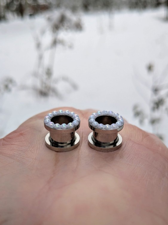 Stainless steel ear tunnels with tiny pearls and soft shimmer
