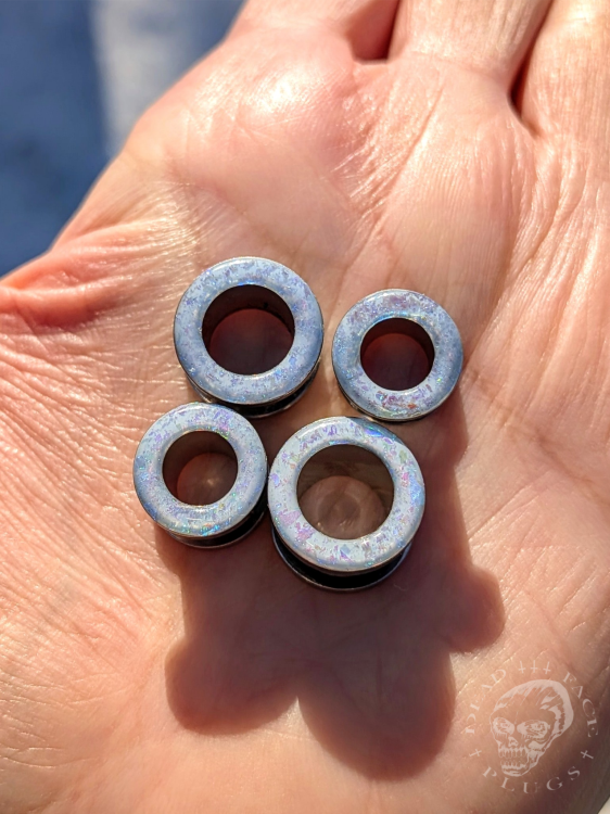 Tunele do uszu z opalizującymi płatkami w kolorach niebieskim, turkusowym i zielonym